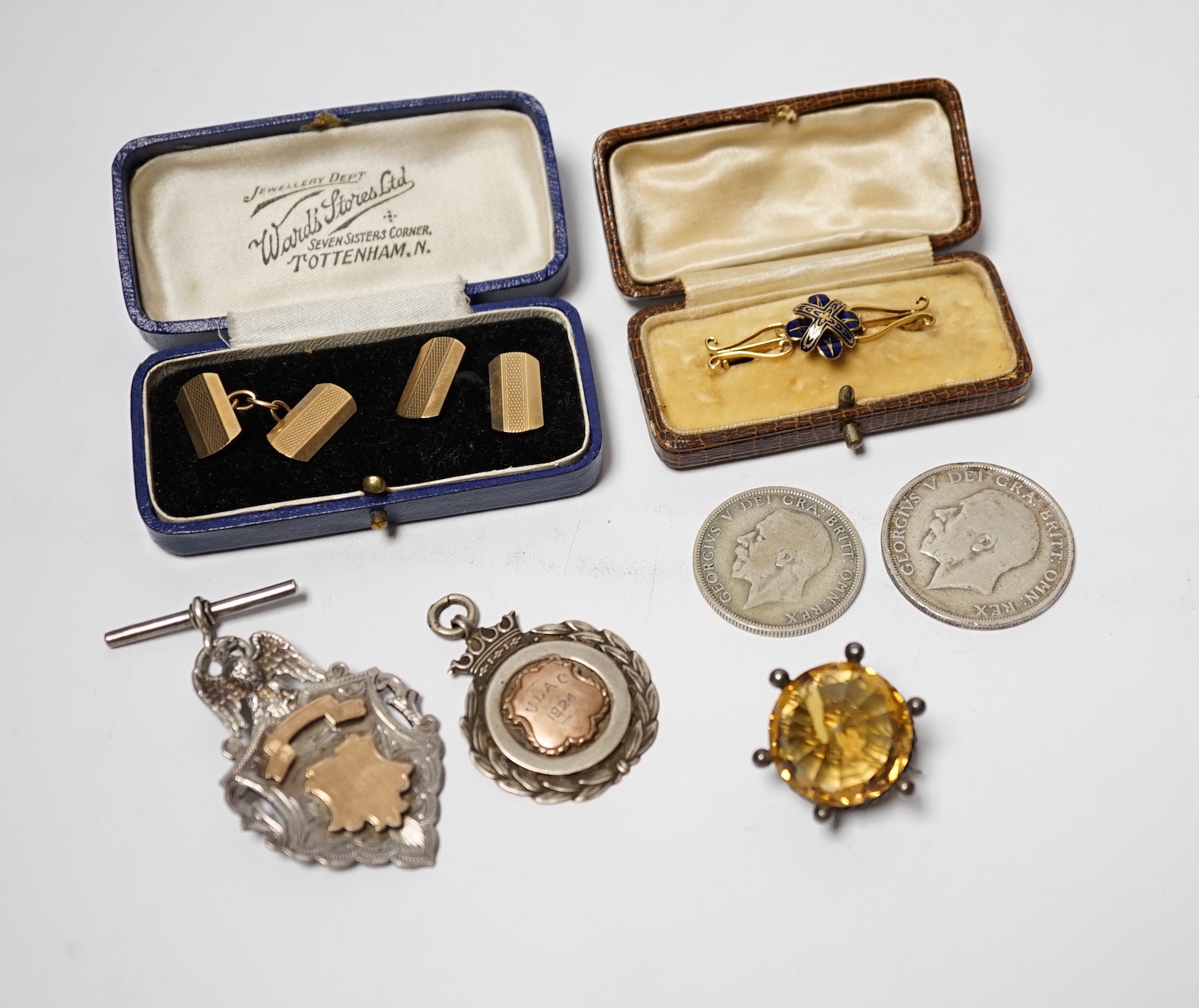 A pair of engine turned 9ct gold cufflinks, a yellow metal and enamel bar brooch, a white metal mounted citrine brooch, two silver medallions and two George V coins.